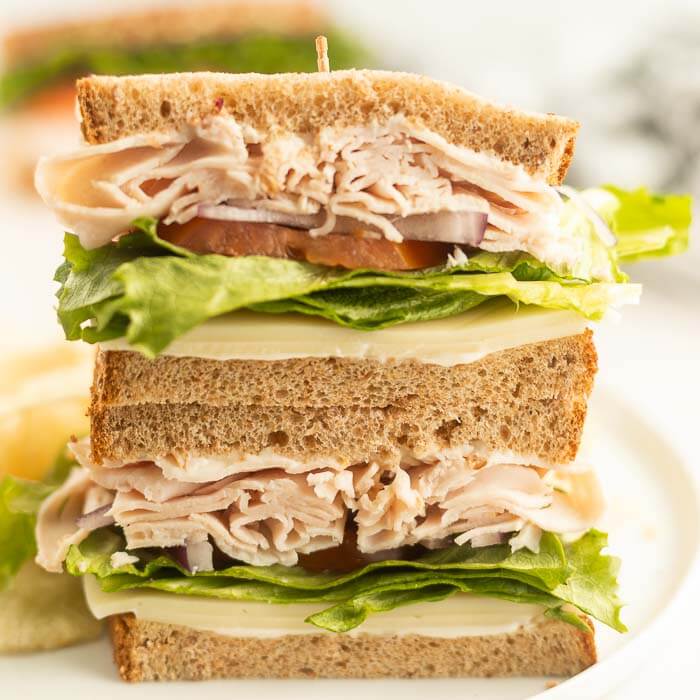 Close up of  turkey sandwich sliced in half. 