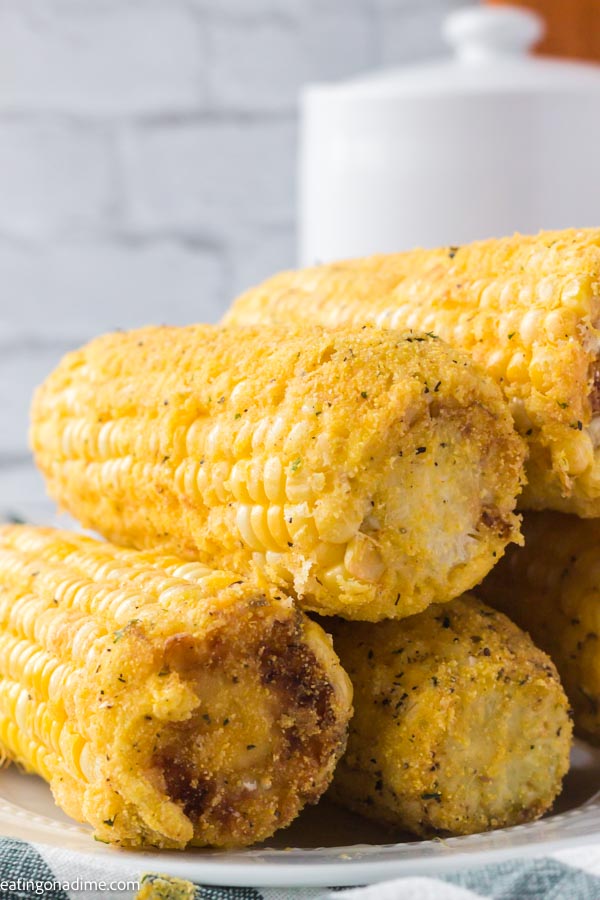Close up image of fried corn on the cob on a white plate. 