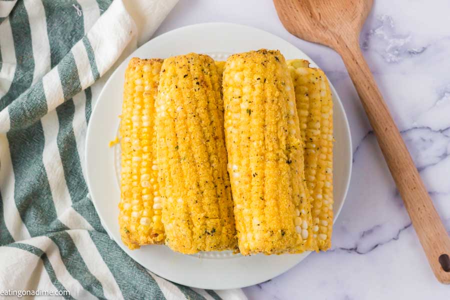Close up image of fried corn on the cob on a white plate. 
