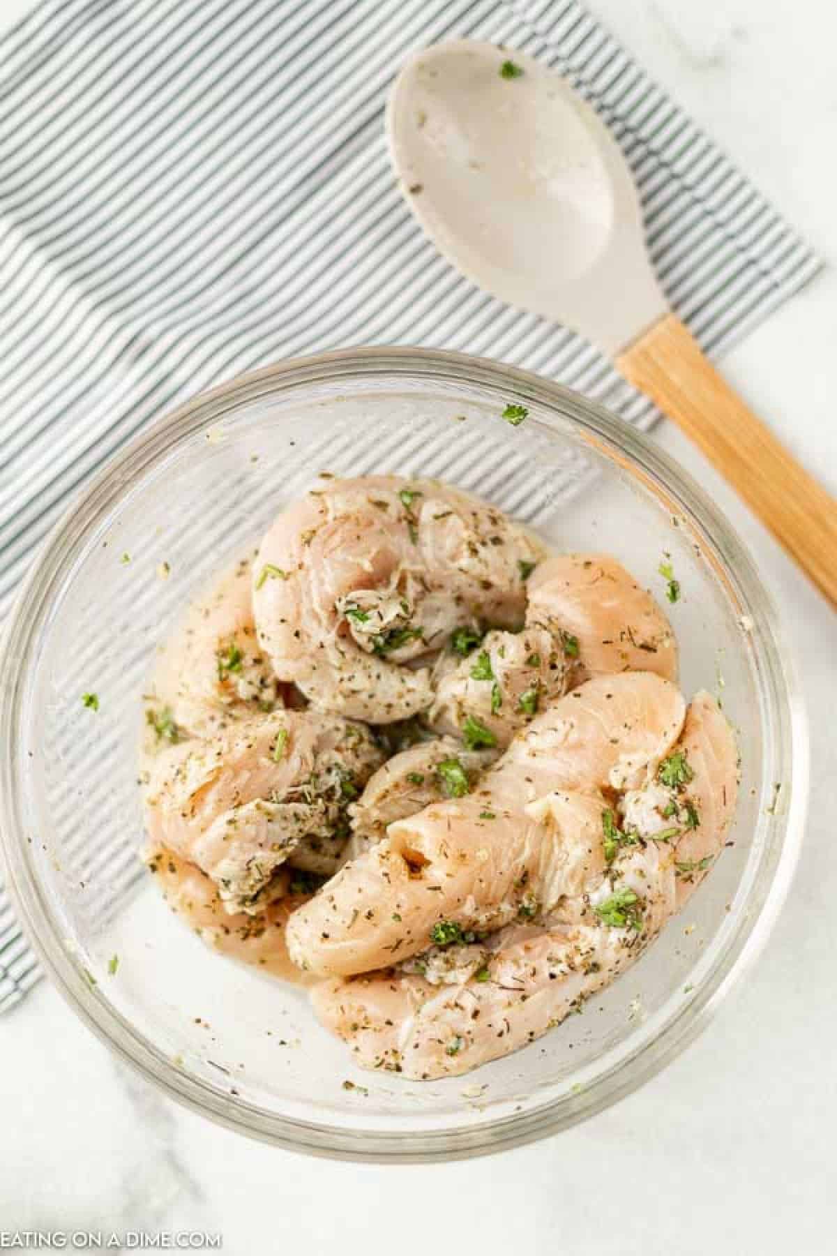 Chicken Tenders in a bowl with seasoning. 