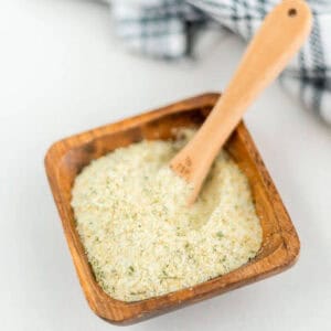 Garlic salt in a bowl with a teaspoon in the bowl.