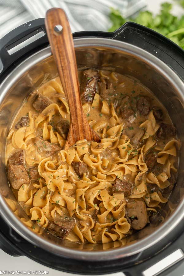 Beef Stroganoff in the instant pot with a wooden spoon 