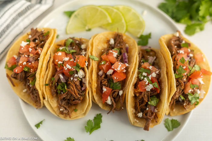 Close up image of carne asada tacos on a white plate. 