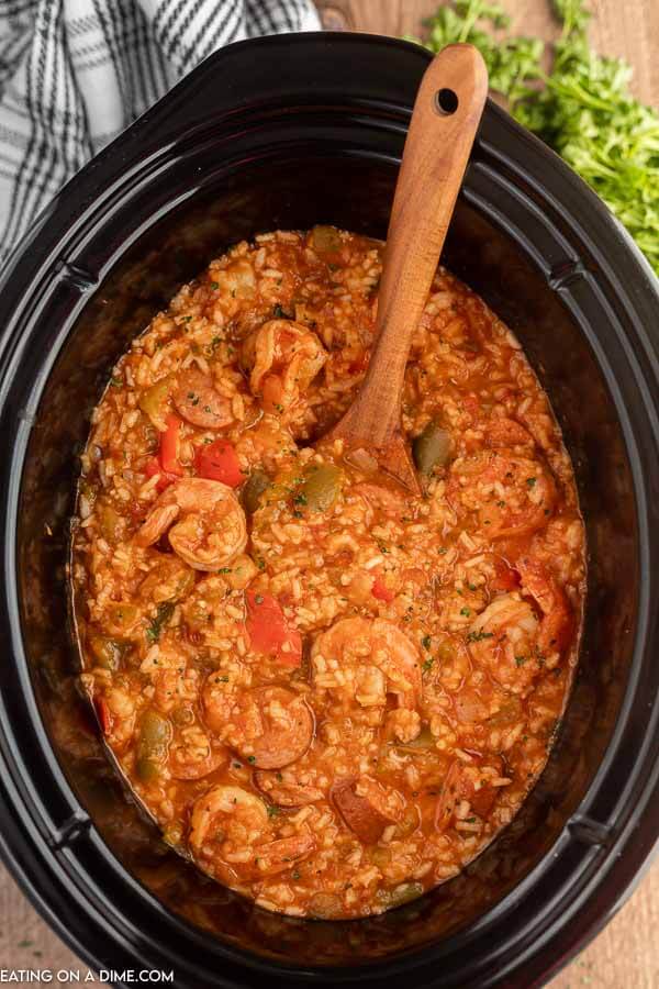 Close up image of Shrimp Jambalaya in the crock pot with a wooden spoon