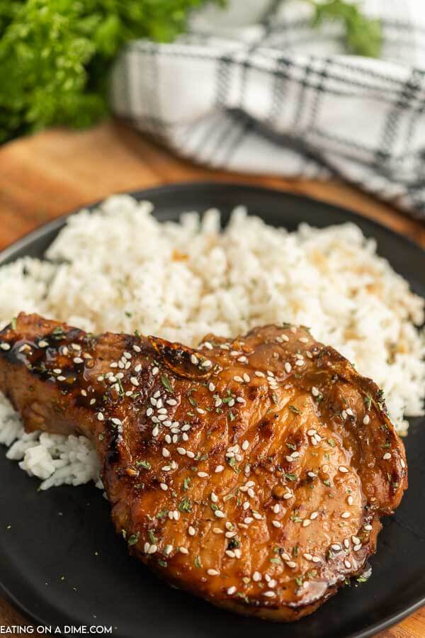 Grilled teriyaki pork chops on a plate with rice. 