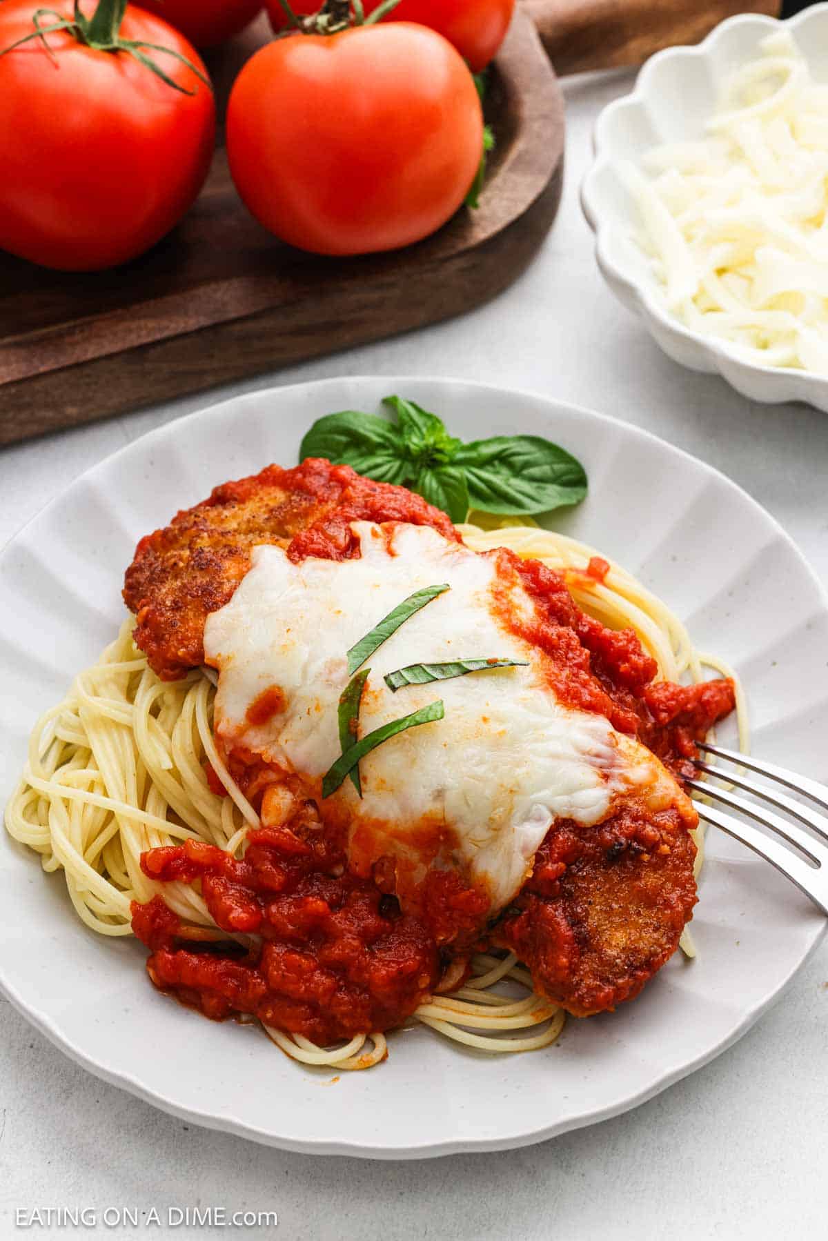A serving of crispy chicken and marinara sauce over spaghetti noodles topped with melted cheese.