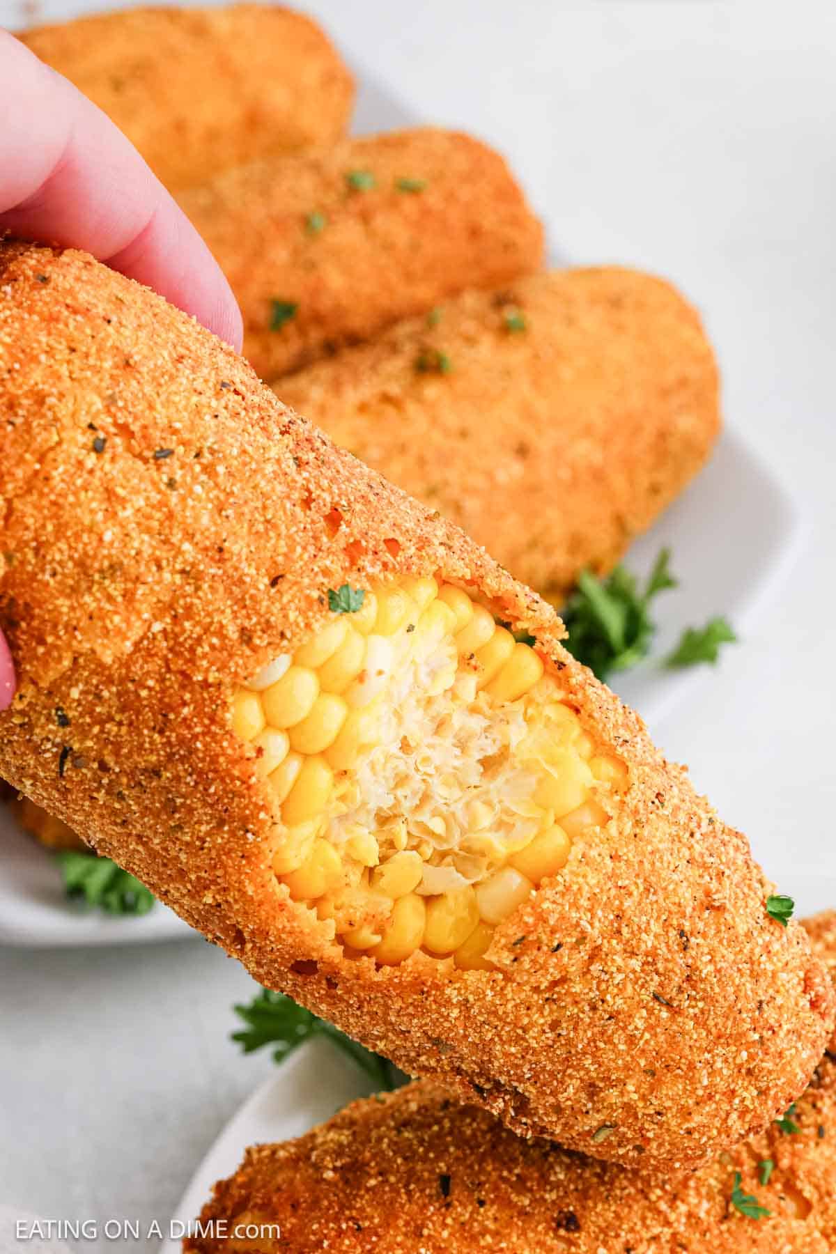 Fried Corn on the cob with a bite into showing the corn kernerls
