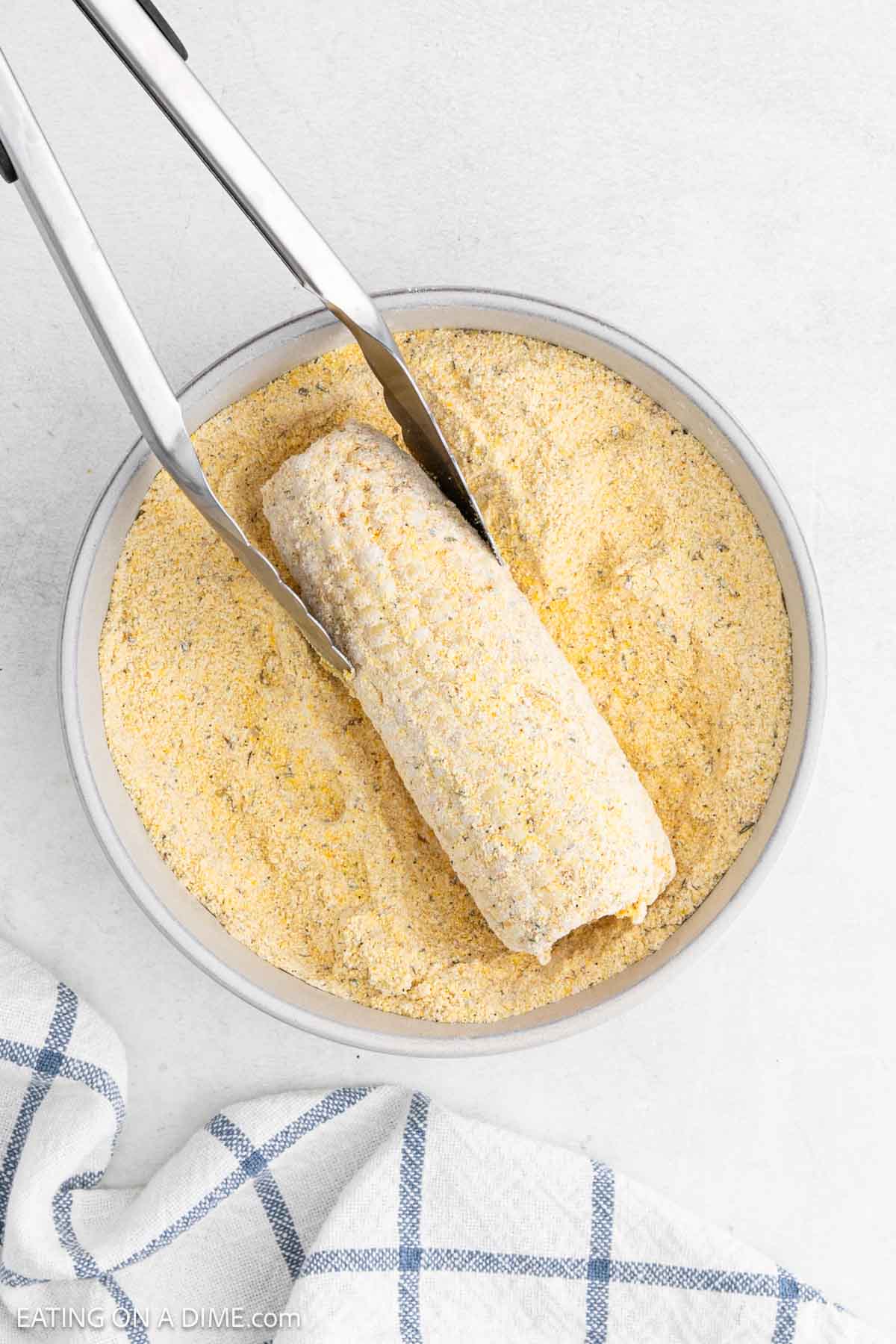 Rolling the corn of the cob in the seasoning mixture