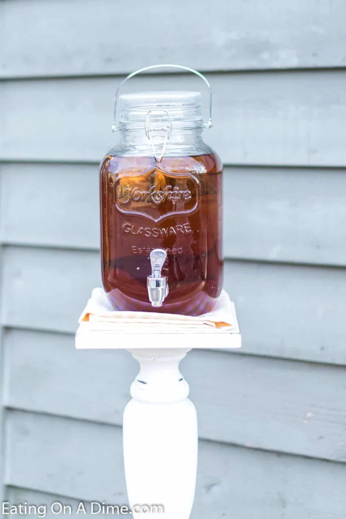 Tea in a glass serving pitcher on a stand