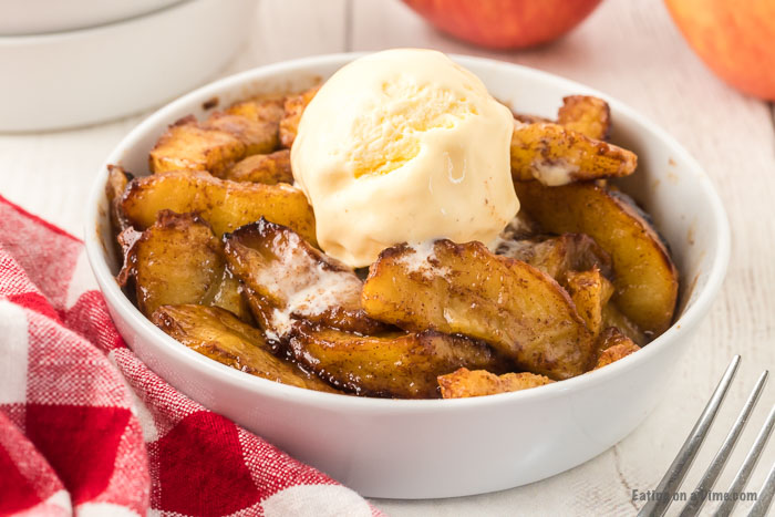 Air fryer apples in a bowl topped with ice cream.