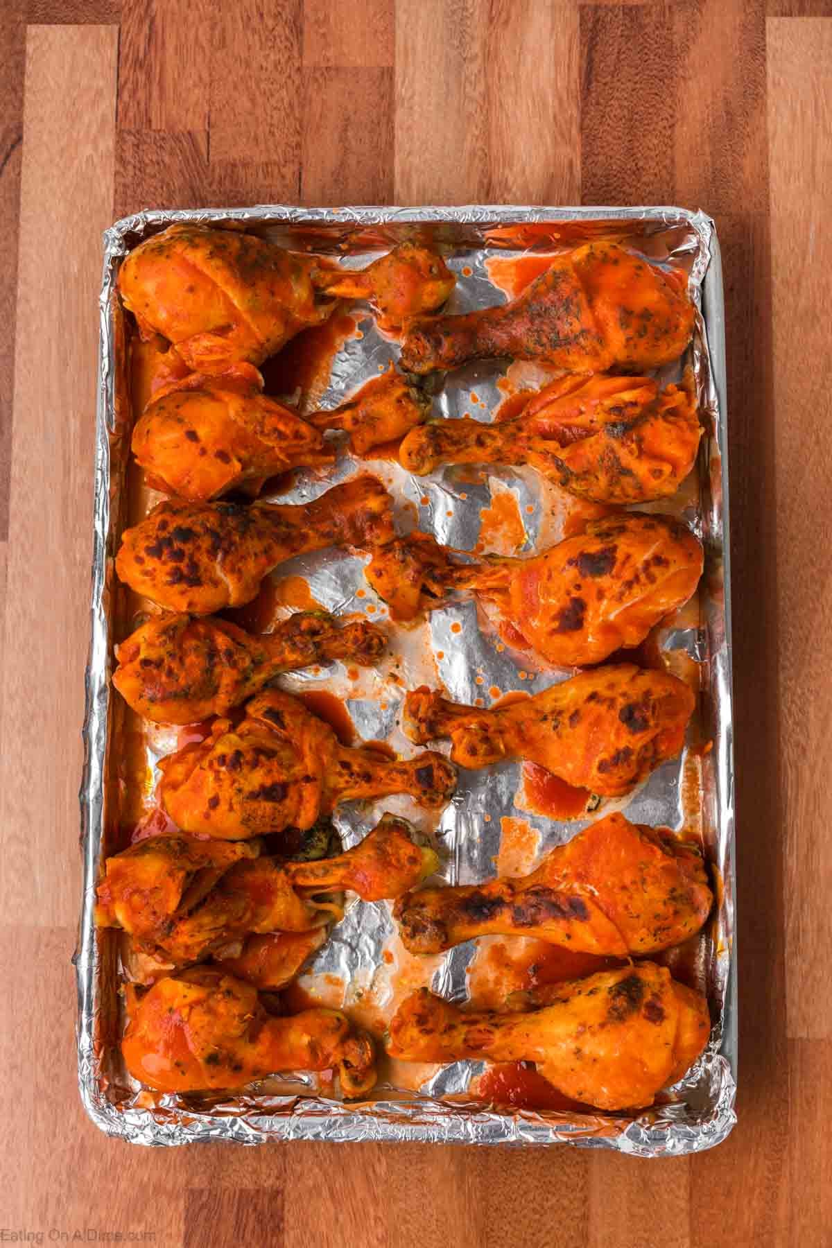Buffalo Chicken Legs placed on a aluminum foil lined baking sheet roasted golden brown