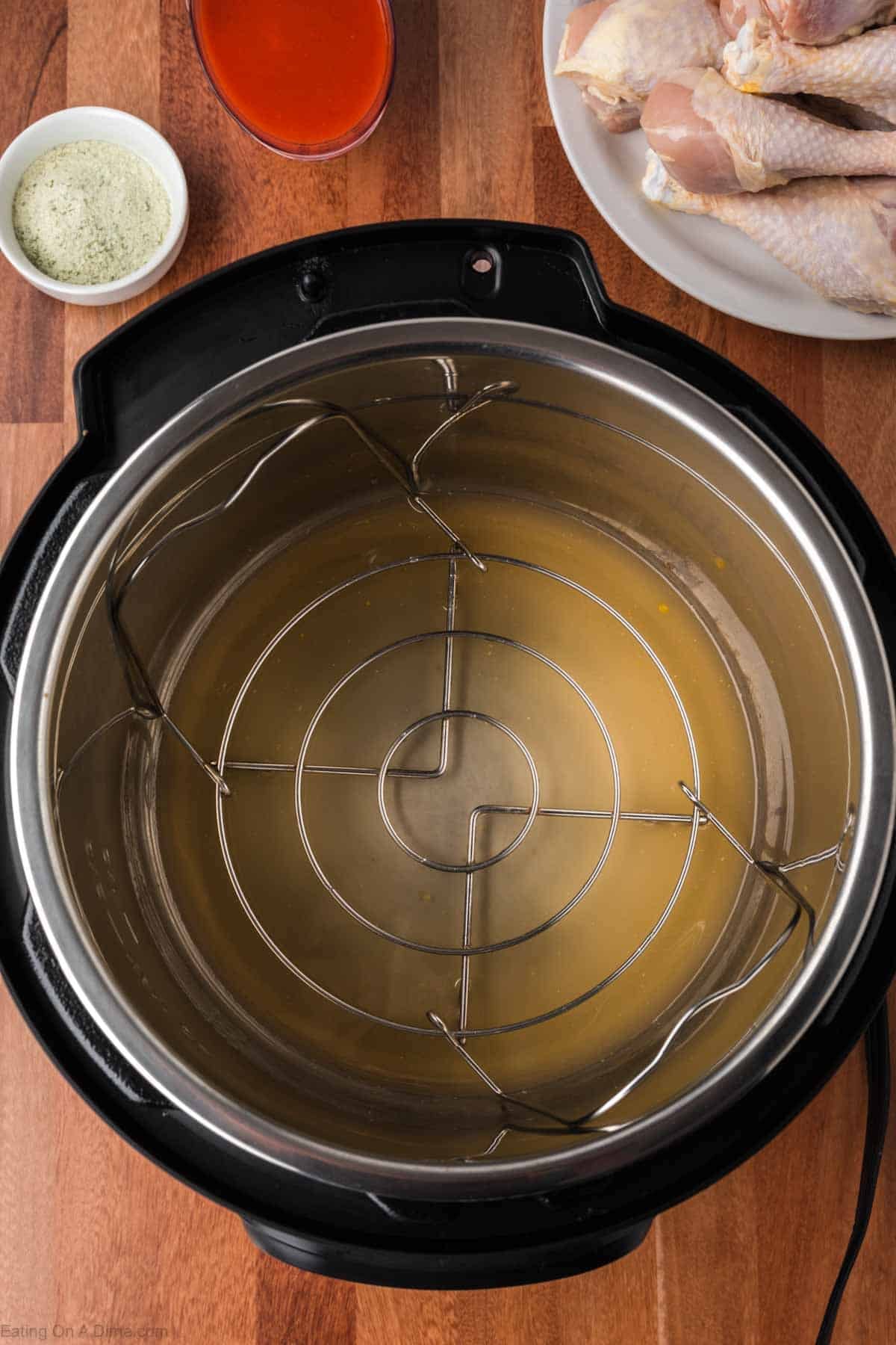 Instant Pot with the trivet with chicken broth poured in