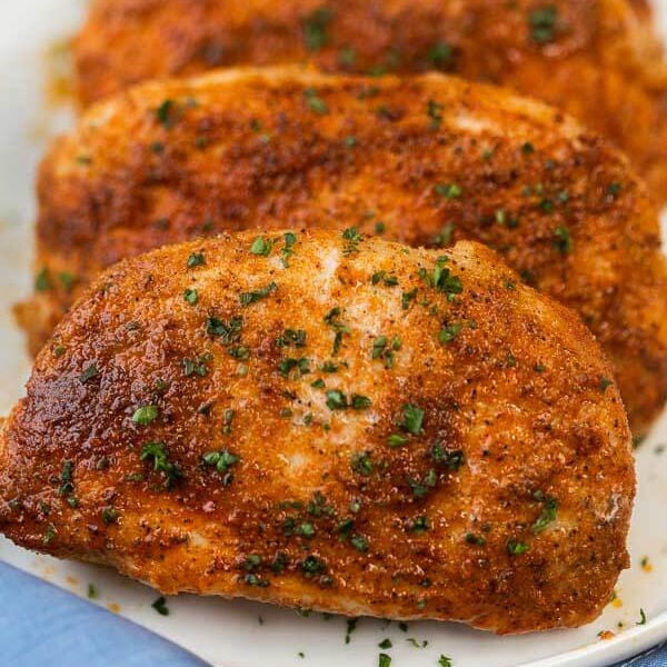 Close up of Boneless pork chops stacked together on a plate 