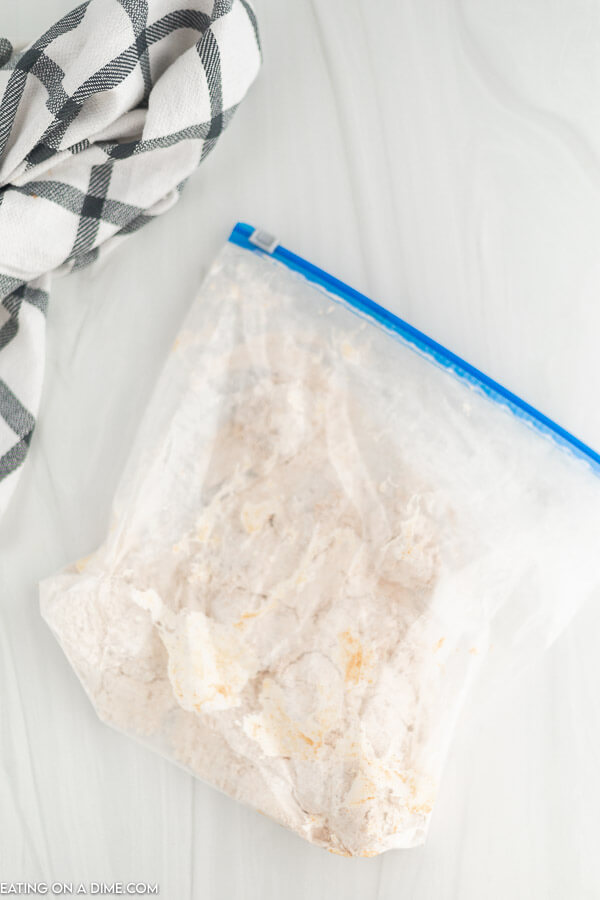 chicken wing in a zip lock bag of flour mixture. 