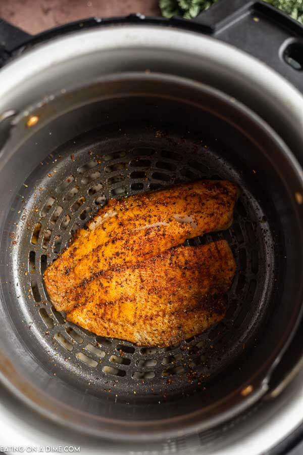 Air fryer tilapia in air fryer basket. 