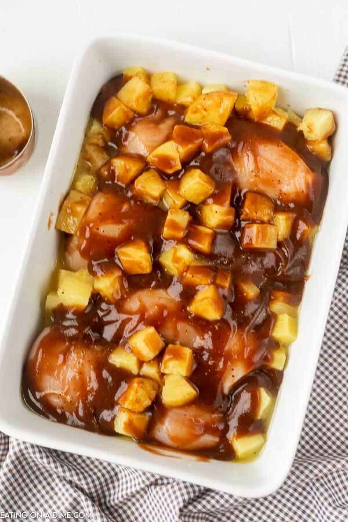 Chicken with BBQ Sauce and pineapple in a baking dish.