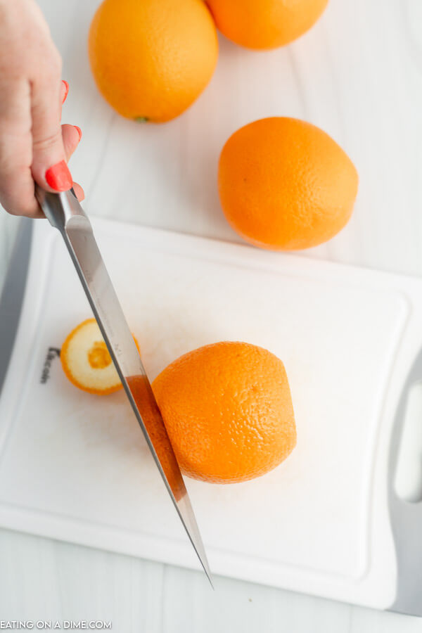 Close up image of cutting the ends off an orange. 