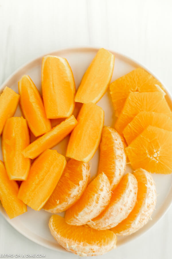 Close up image of orange slices on a white plate. 