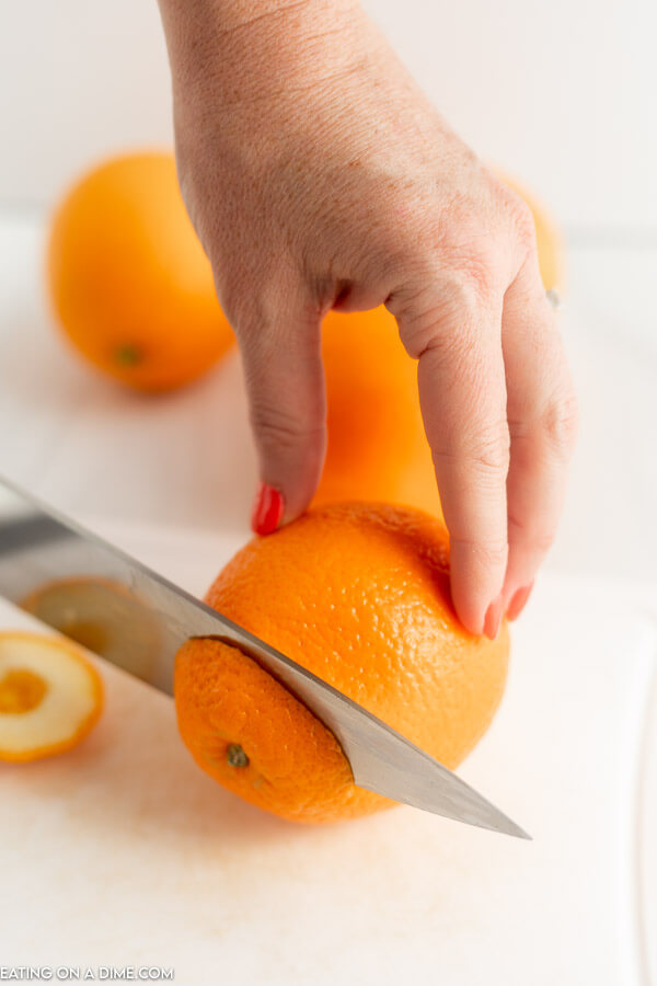 Close up image of cutting the ends off of the orange. 