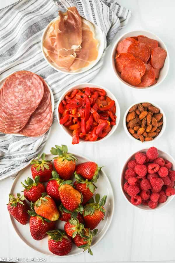 Ingredients in bowls for red white and blue charcuterie board