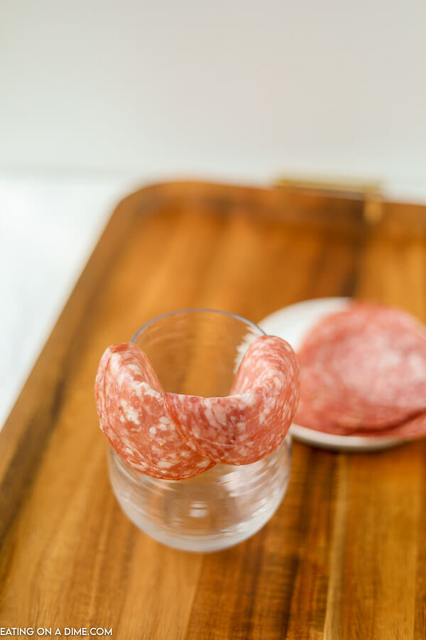 Putting salami on a wine glass