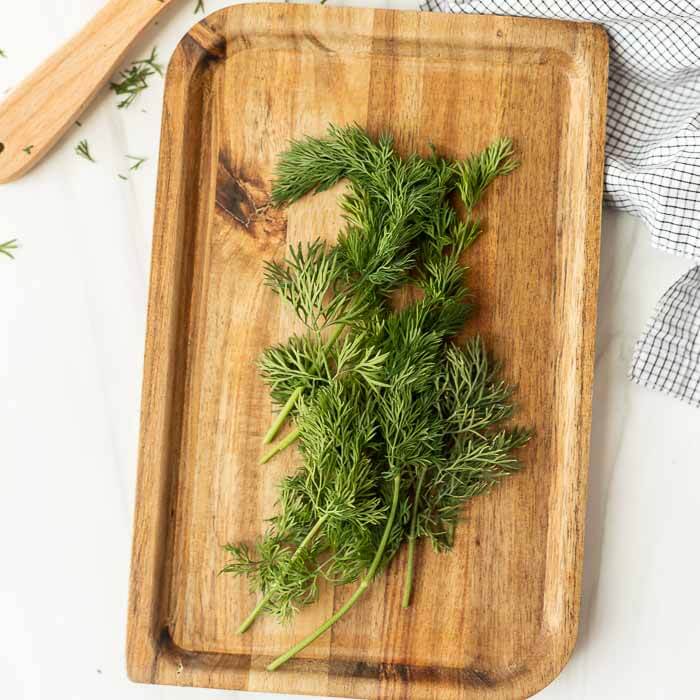 Close up image of fresh dill on a cutting board