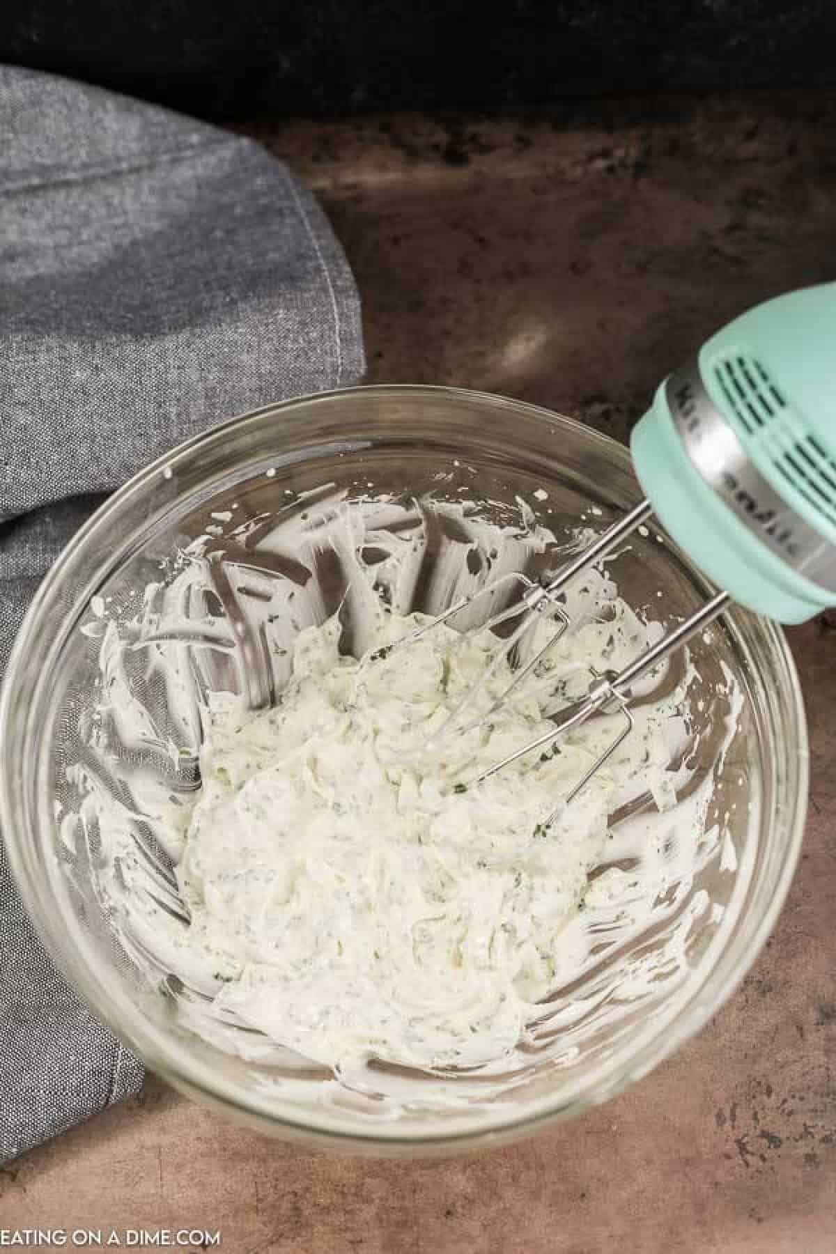 Mixing together garlic butter. 