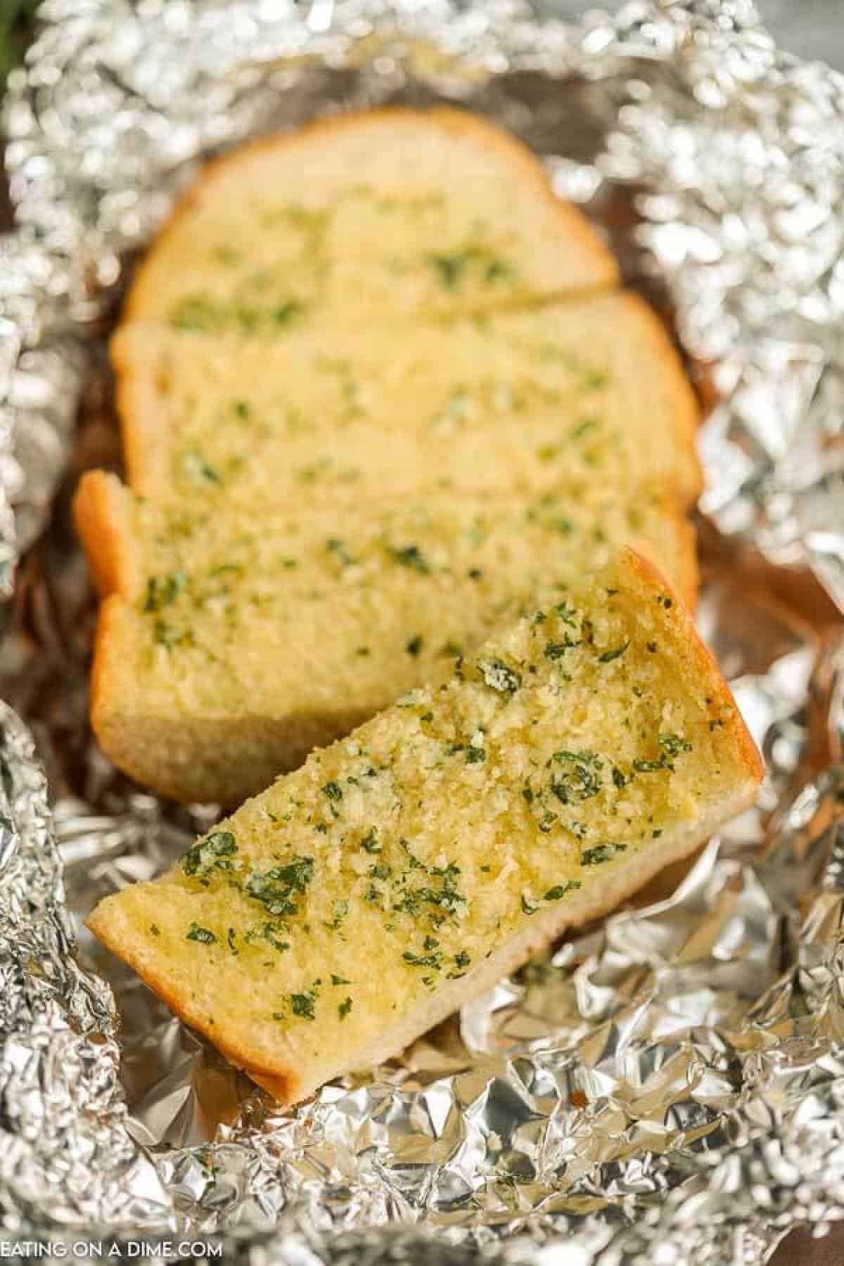 Slices of grilled garlic bread in foil.
