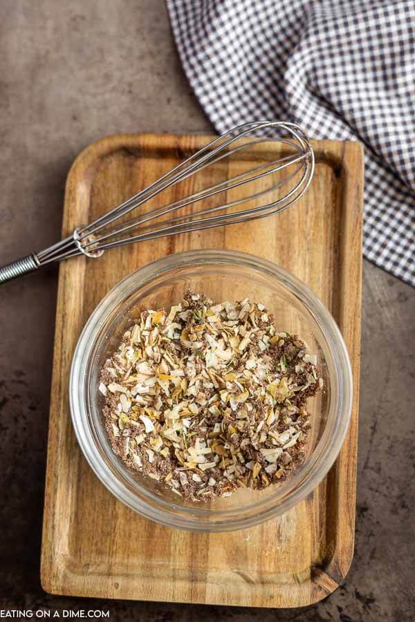 Onion soup mix in a bowl with a whisk on a cutting board