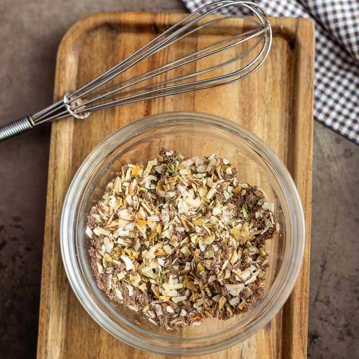 Onion soup mix in a bowl with a whisk on a cutting board