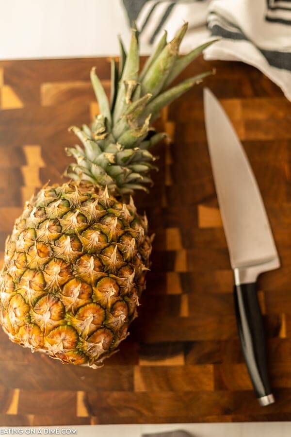 Pineapple and a knife on a cutting board