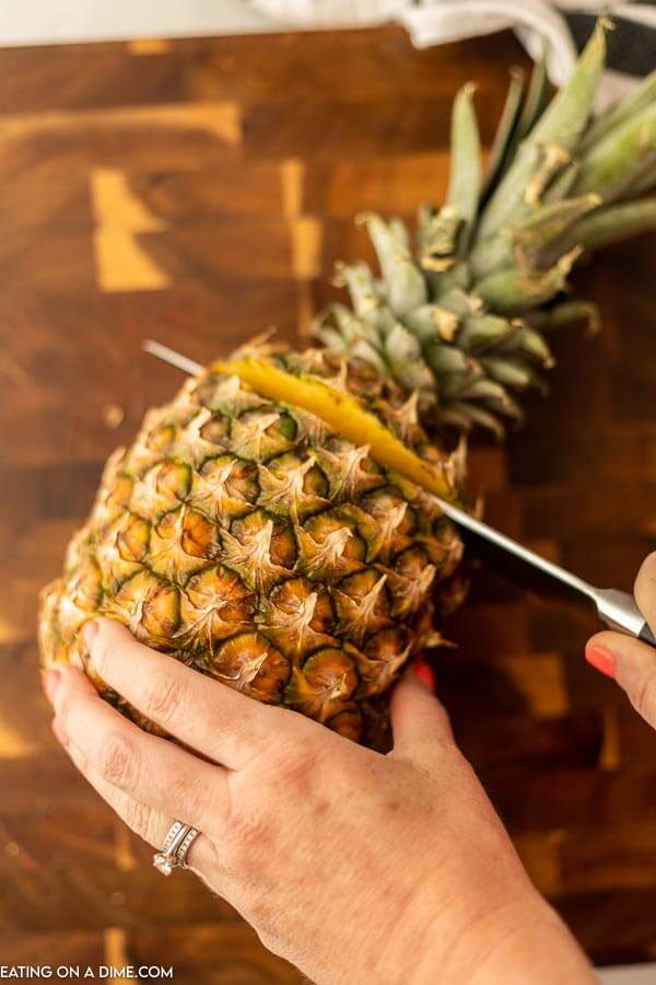 Cutting the top of the pineapple