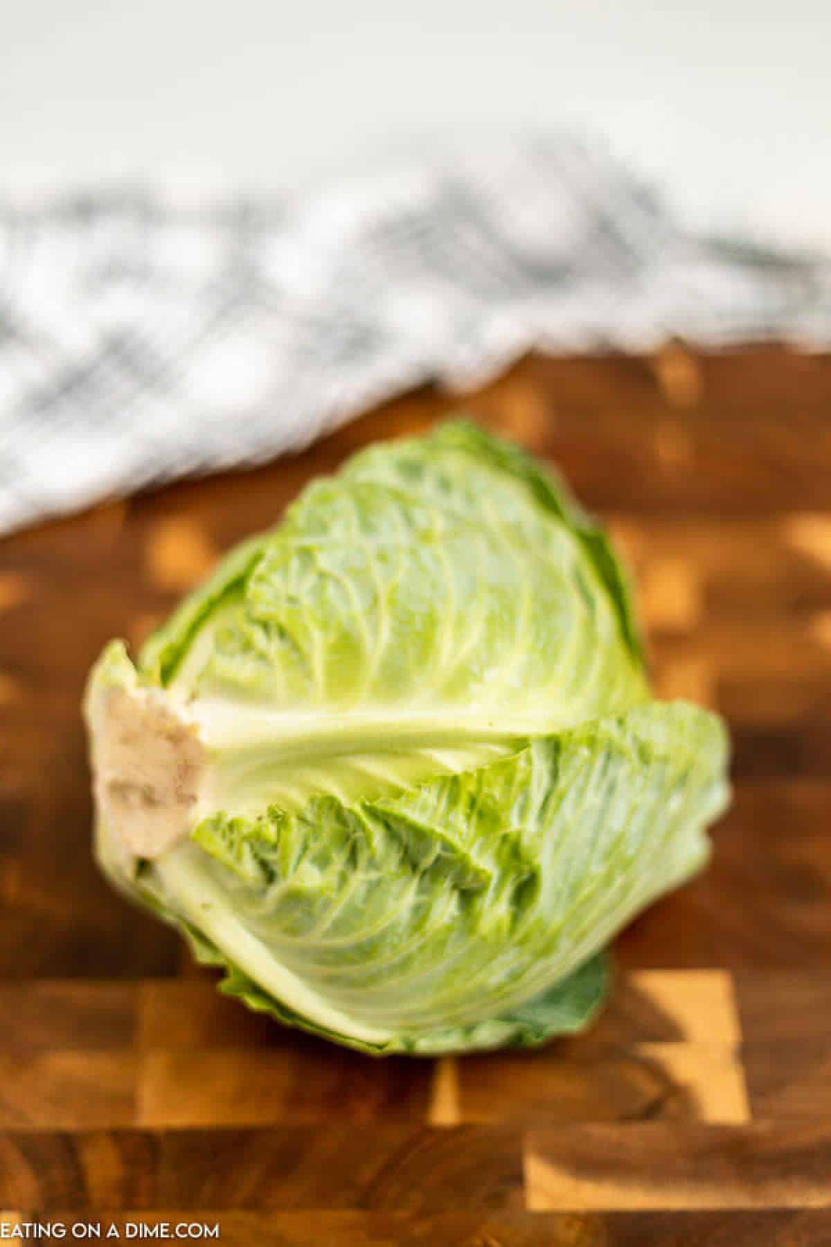 Close up image of whole cabbage on a cutting board.