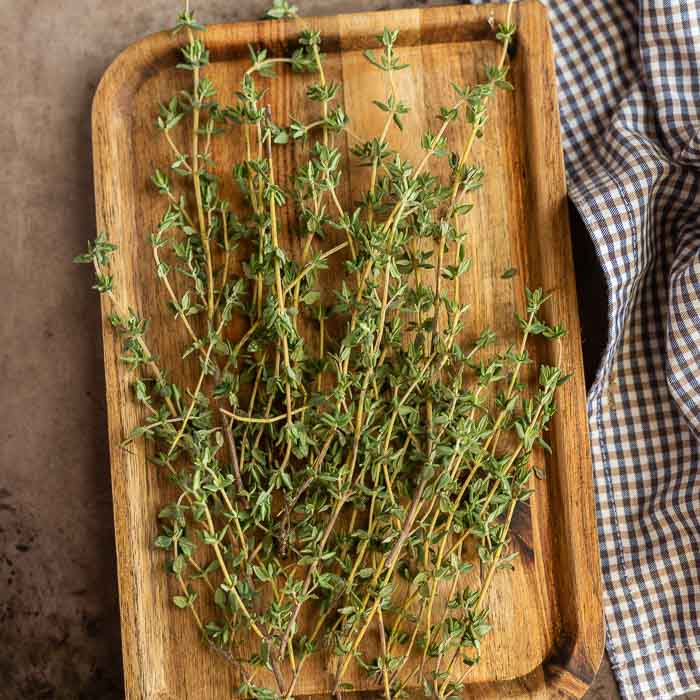 Fresh thyme stems on a cutting board.