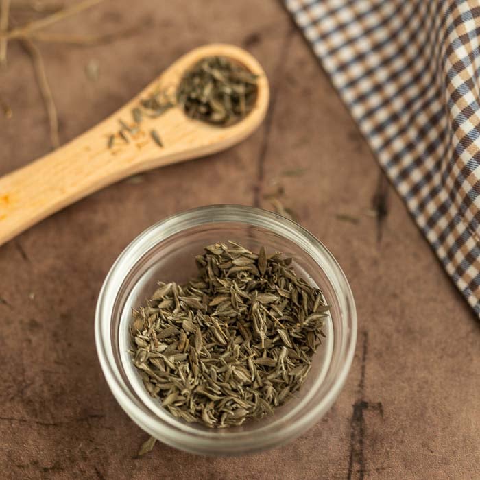 Dried Thyme in a jar with a ¼ teaspoon of dried thyme on the side