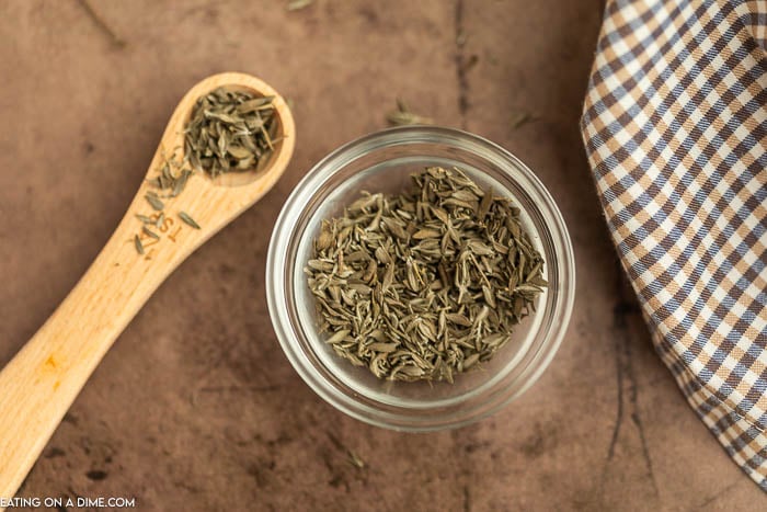 Dried Thyme in a jar with a ¼ teaspoon of dried thyme on the side