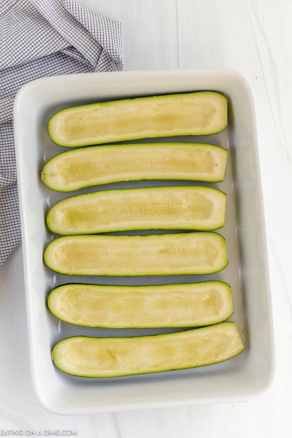 Zucchini boats lined in a baking dish
