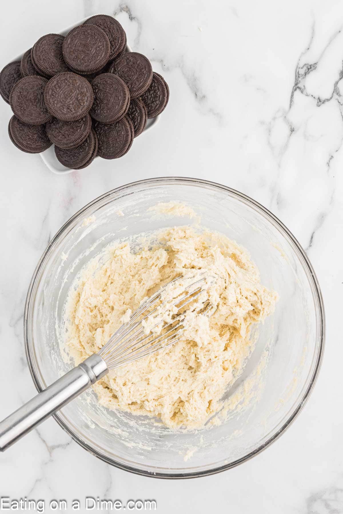 Combining the wet ingredients and dry ingredients with a bowl of Oreo Cookies