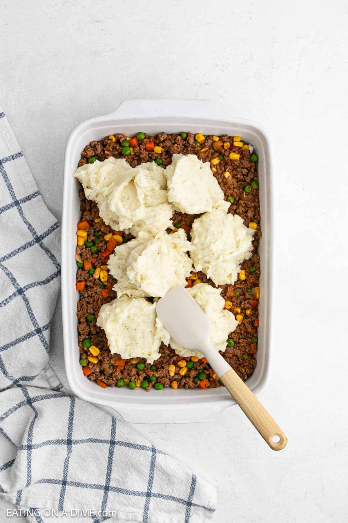 Meat and veggie mixture placed in the baking dish and mashed potato mixture placed on the top.
