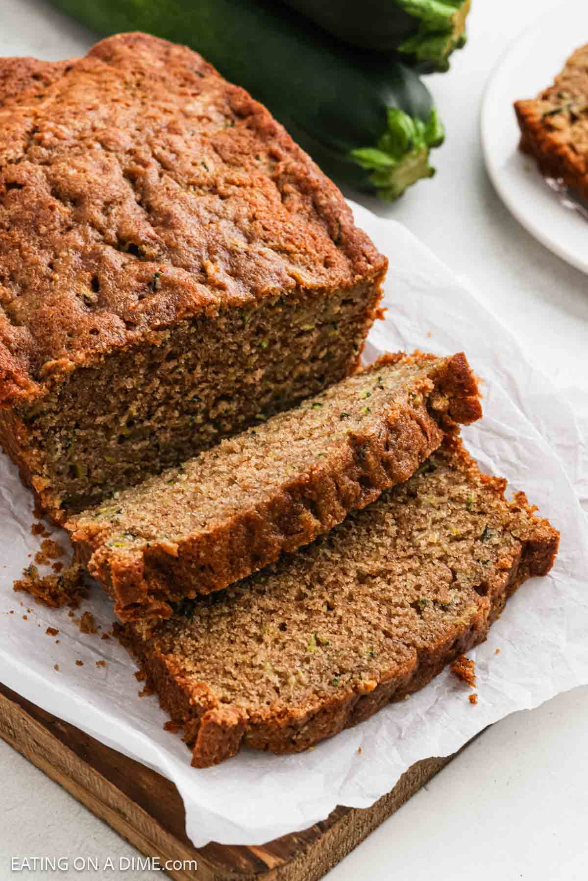 Baked bread on a wooden platter with parchment paper.