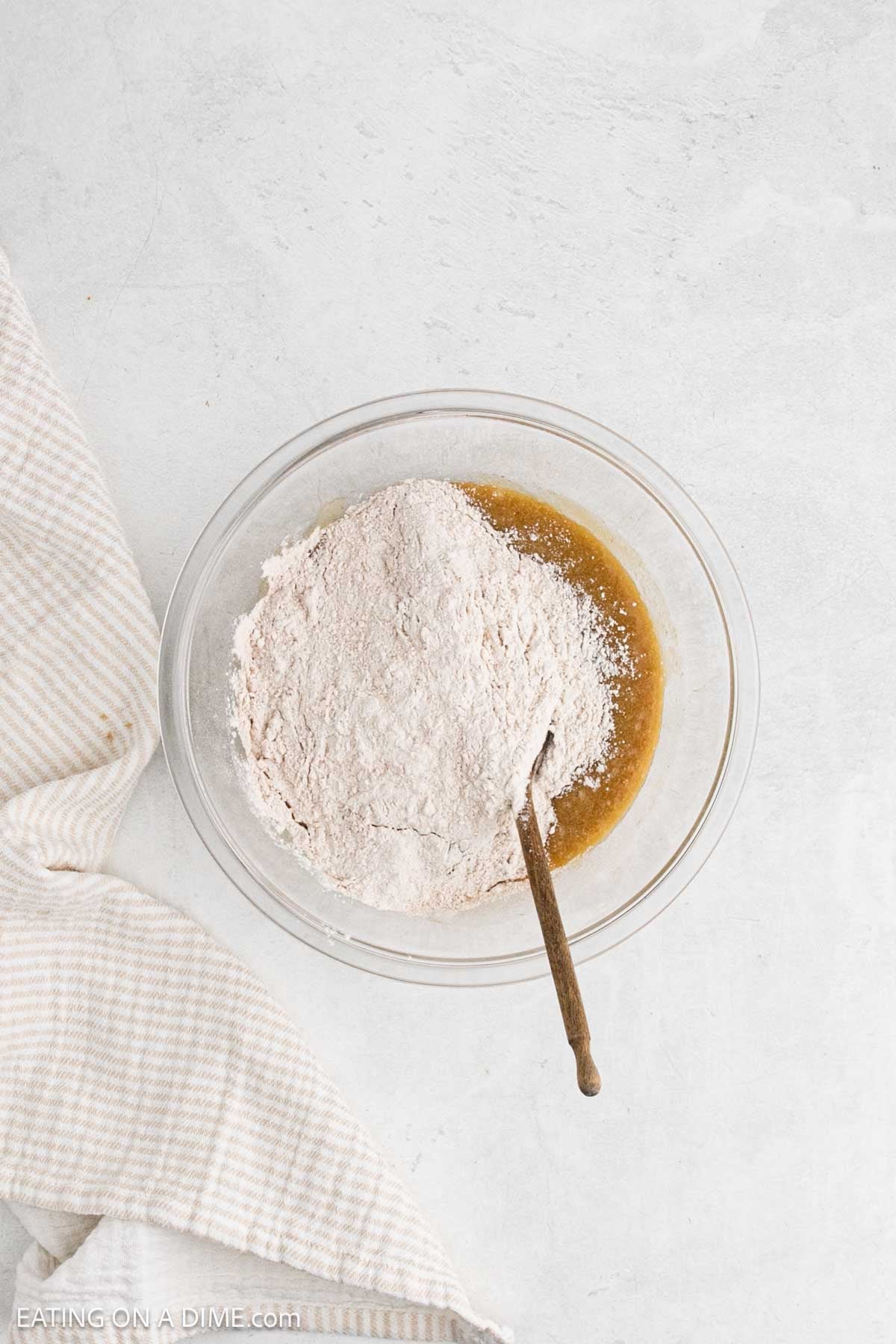 Adding the flour mixture with the egg mixture in a bowl.