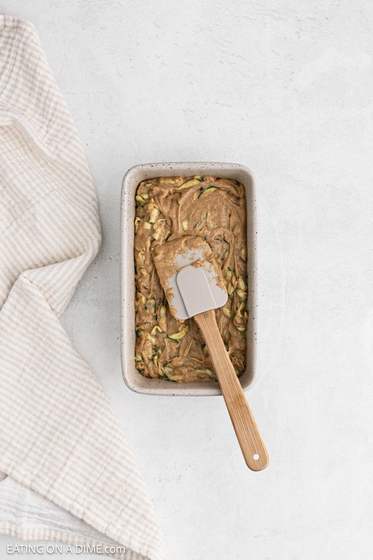 Spreading the bread batter in a loaf pan.