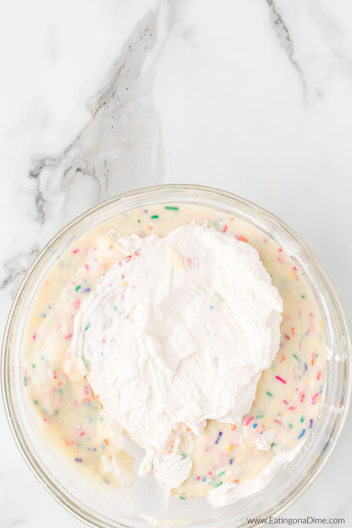 Combining the heavy cream and cake mix mixture together in a bowl.