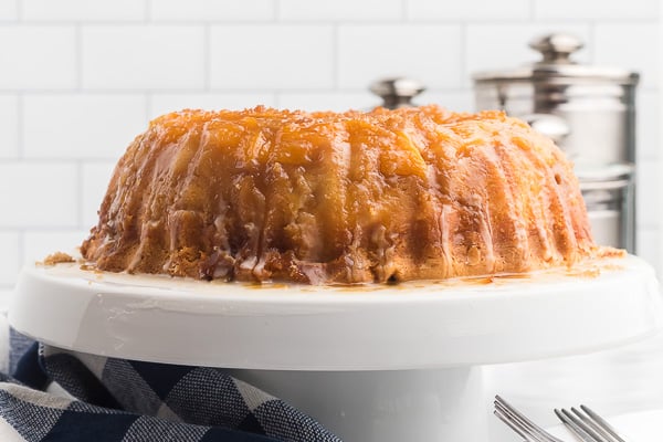 A whole peach cobber cake on a cake stand