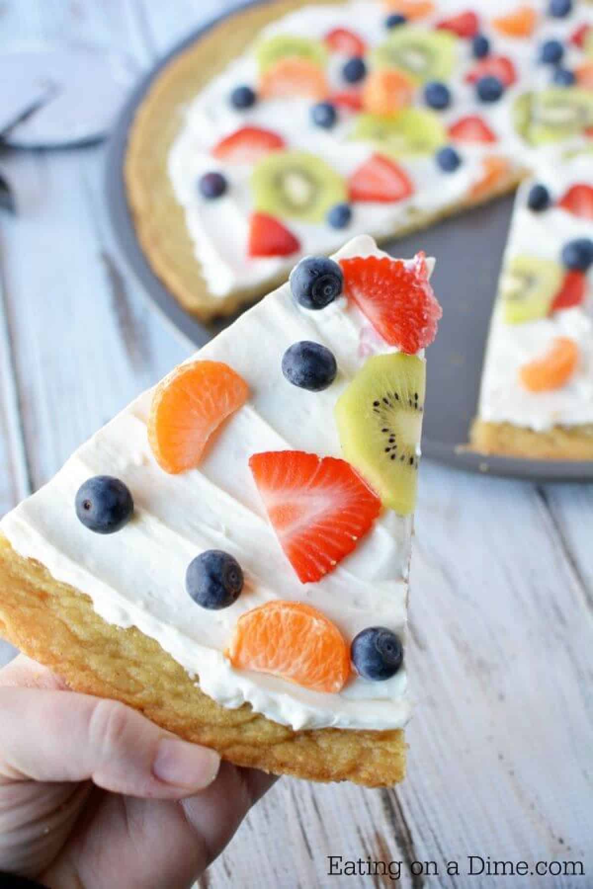 Make this delicious Sugar Cookie Fruit Pizza and you will not be disappointed! This Easy Fruit Pizza Recipe is amazing! You will love this fruit pizza with sugar cookie crust. Yum! Fruit pizza recipe sugar cookie will be a hit. Close up image of a fruit pizza sliced.