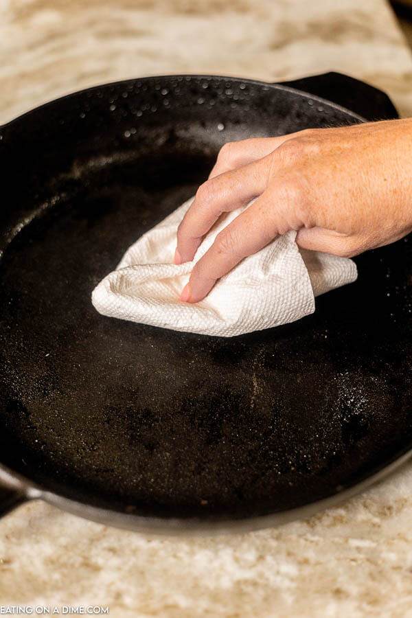 Drying the cast iron skillet with a paper towel