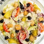 Close up of a bowl of salad topped with parmesan cheese.