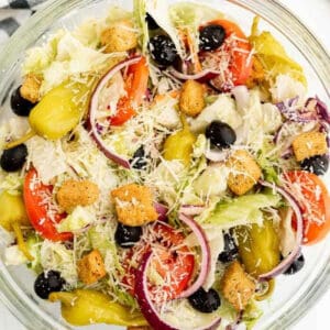 Close up of a bowl of salad topped with parmesan cheese.