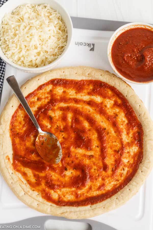 Sauce spread on the pizza crust. 