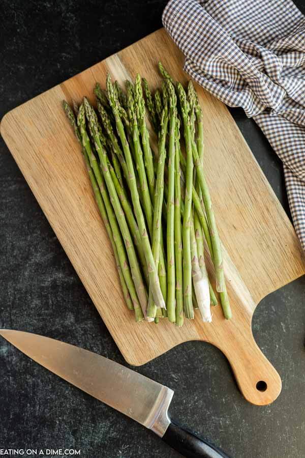 Asparagus on a cutting board with a knife